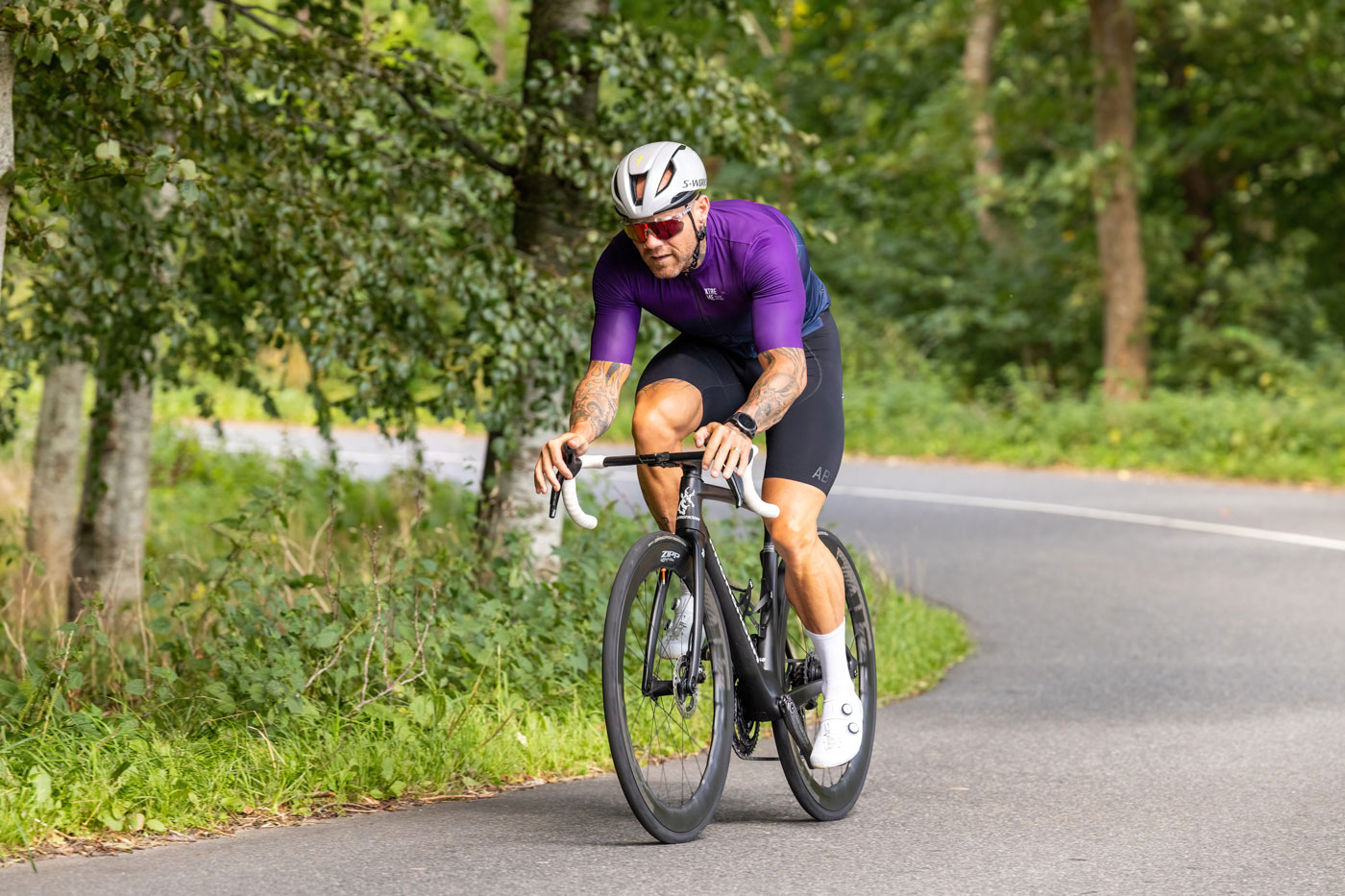 Anders på en racer-cykel på vej ned af en skovvej.